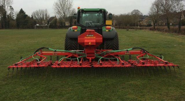 Flexi tine harrows behind a tractor on a pitch