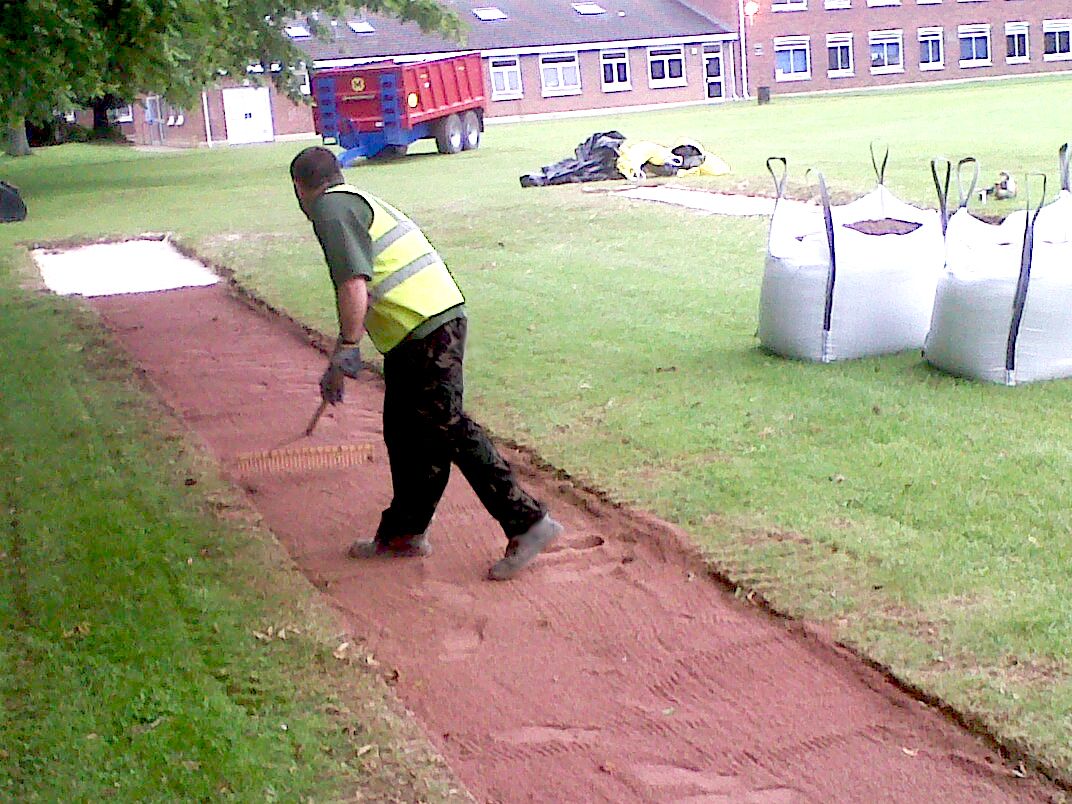 Raking a long jump sand pit