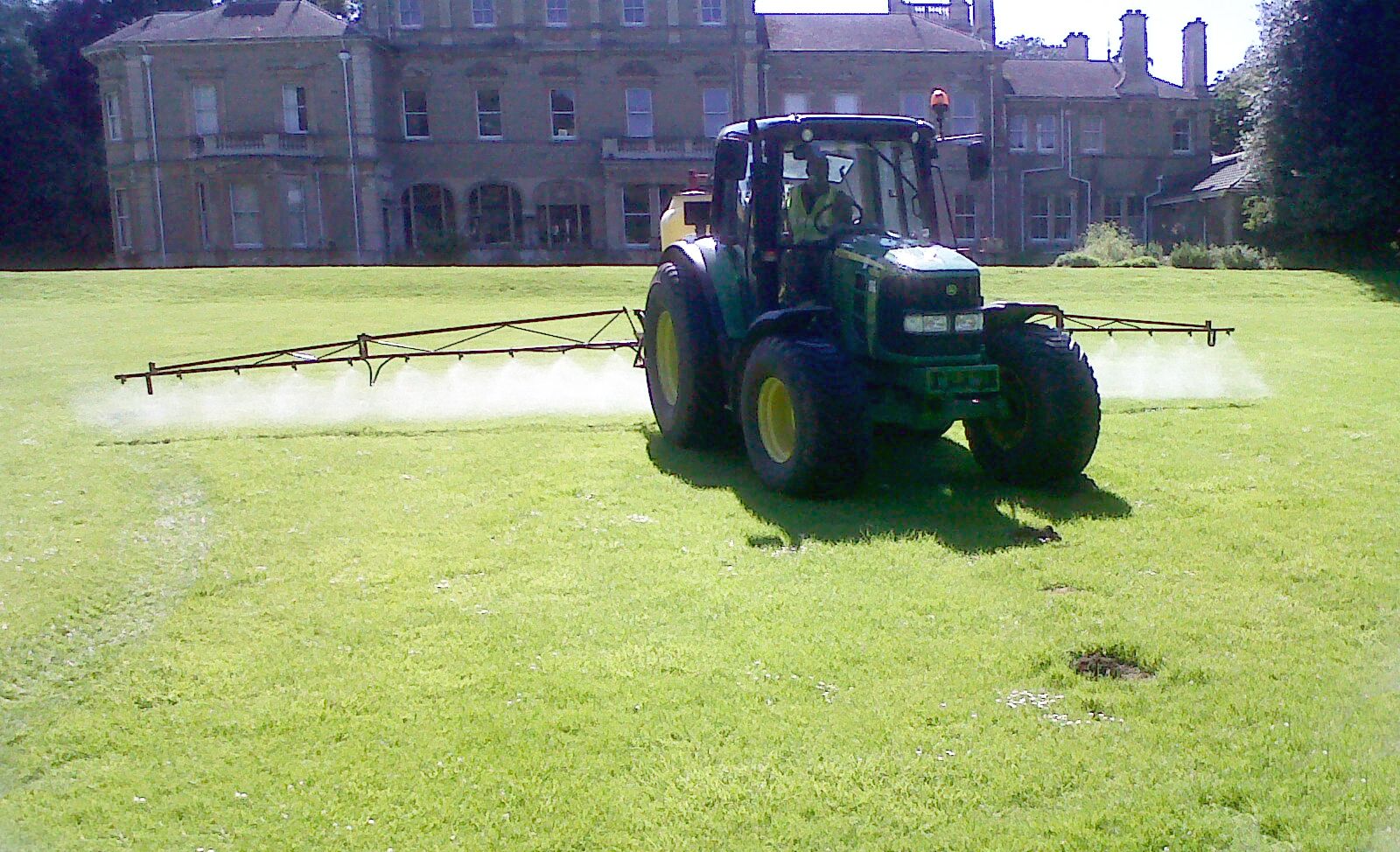 Tractor-mounted sprayer on a sports field